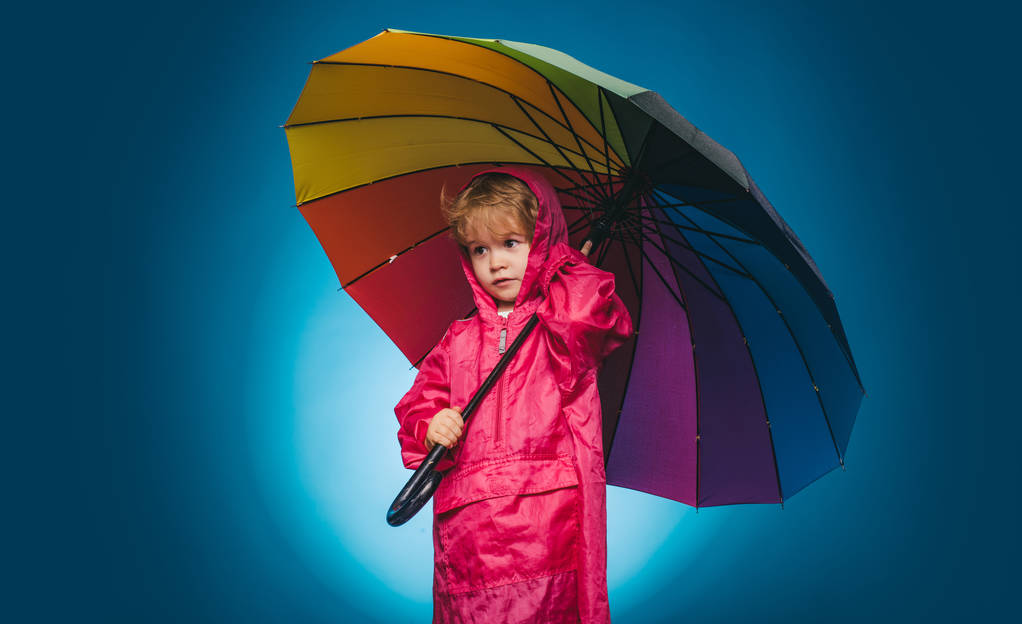 Sprzedaż dla całej kolekcji jesień dzieci, niesamowite zniżki i znakomity wybór. Wesoły chłopak w płaszcz z kolorowym parasolem. Ładny mały chłopiec przygotowują się do jesieni, słoneczny dzień. Dziecko w deszczu. - Zdjęcie, obraz