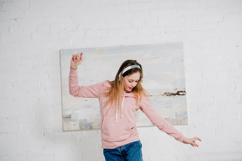 Έφηβος παιδί ακούγοντας μουσική στα ακουστικά και χορεύοντας στο υπνοδωμάτιο - Φωτογραφία, εικόνα