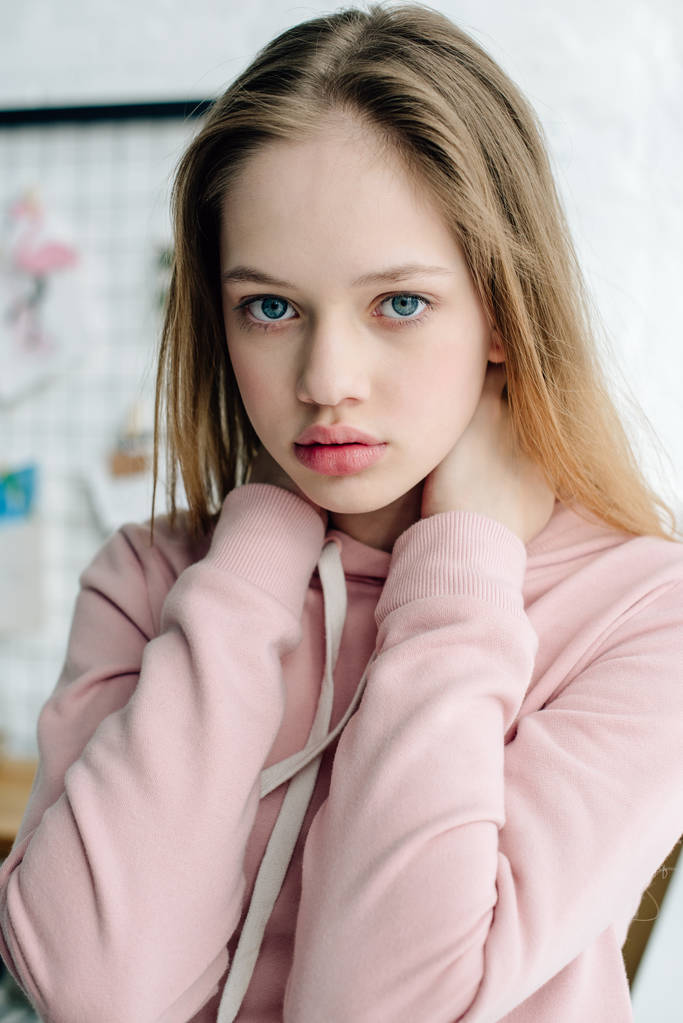 Teenage Child in Casual Pink hoodie kijken naar camera - Foto, afbeelding