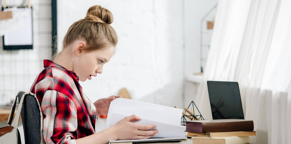 Panoramaaufnahme eines Teenagers im rot karierten Hemd bei den Hausaufgaben - Foto, Bild