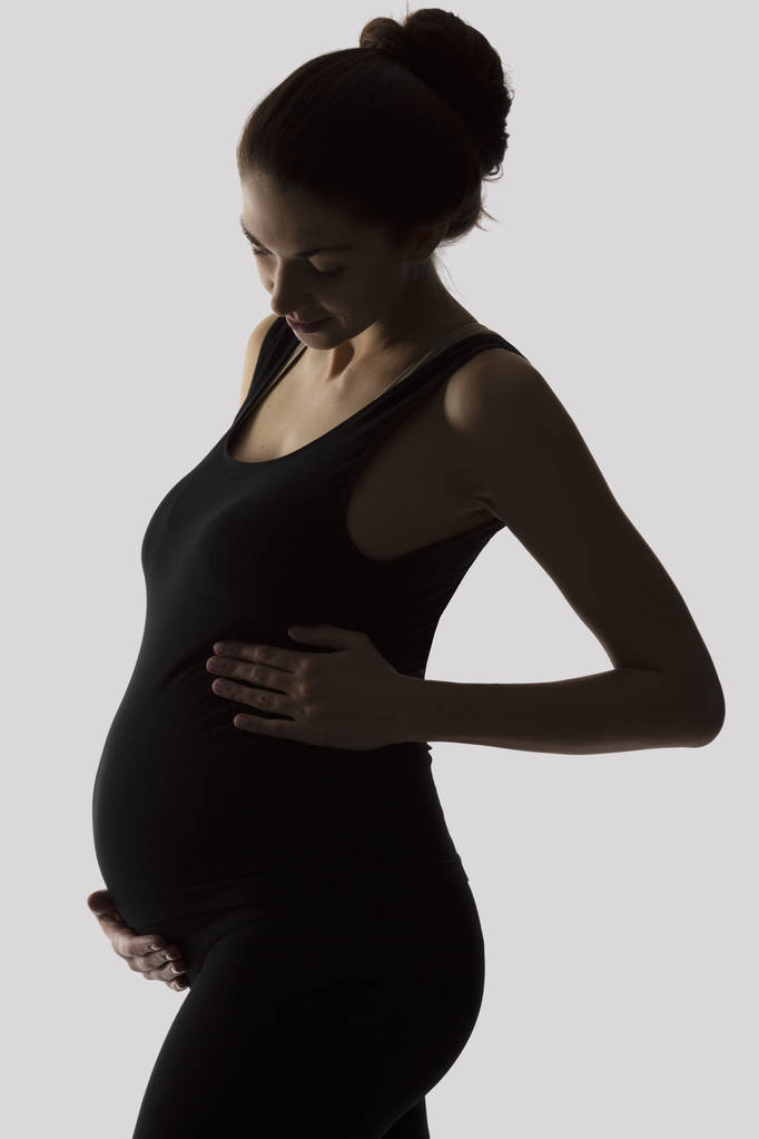 Šťastná těhotná žena čeká. Izolované na světle šedém pozadí. - Fotografie, Obrázek