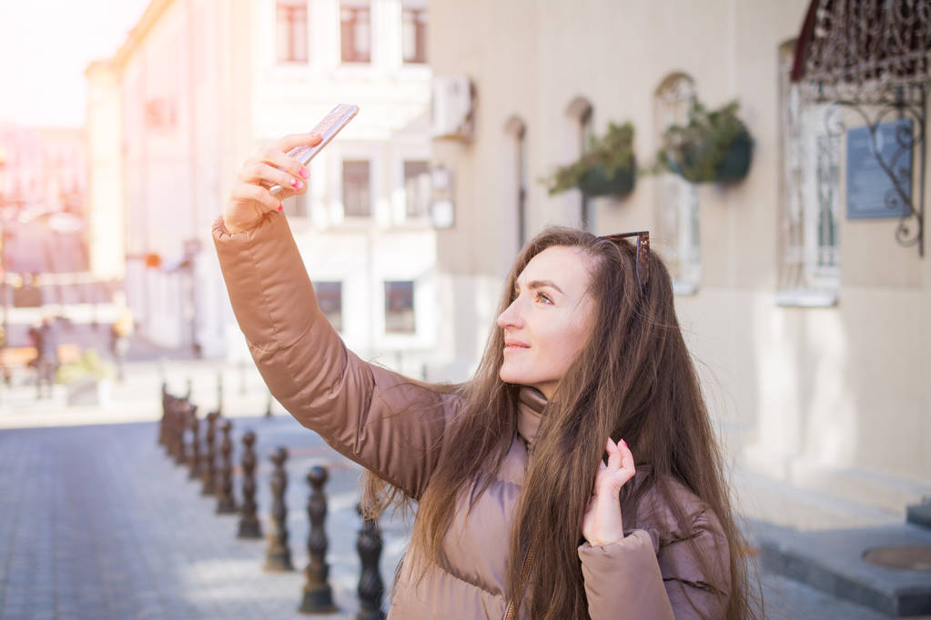 Νέων ελκυστικών τουριστικών παιχνιδιάρικο κάνει selfie στο τηλέφωνο - Φωτογραφία, εικόνα