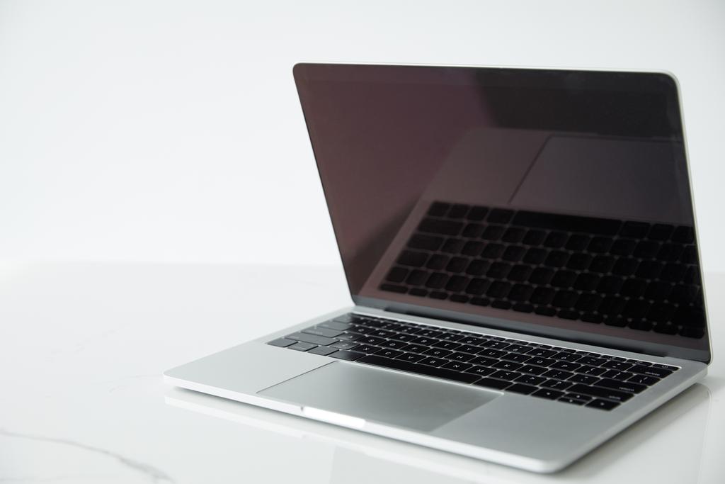 laptop met leeg scherm en zwart toetsenbord op wit oppervlak geïsoleerd op wit - Foto, afbeelding