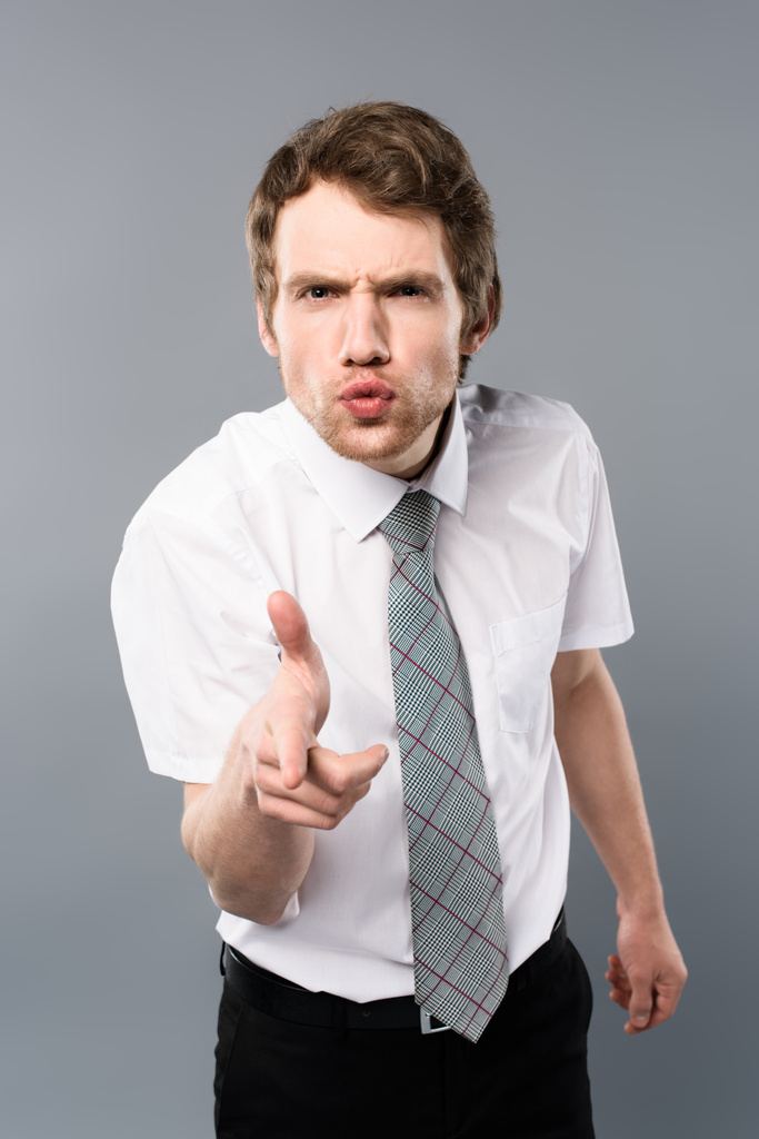 сердитий бізнесмен зі смішним виразом обличчя, що вказує пальцем на камеру
 - Фото, зображення