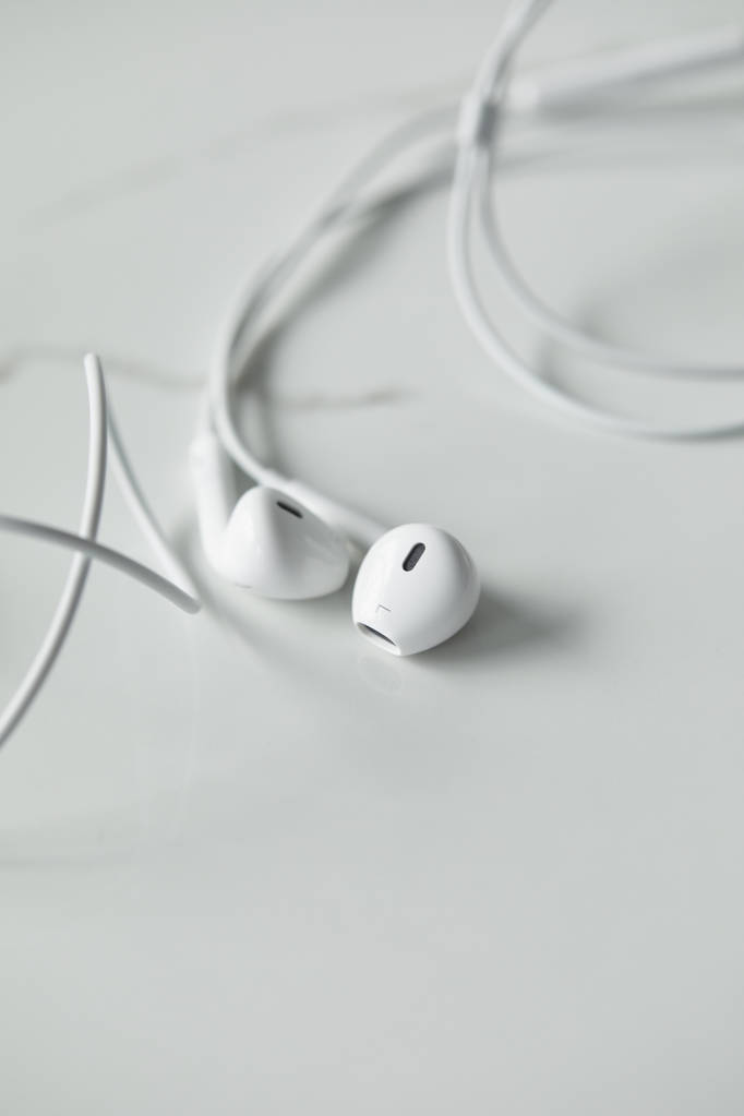 mise au point sélective des écouteurs filaires blancs sur une surface blanche avec espace de copie
 - Photo, image