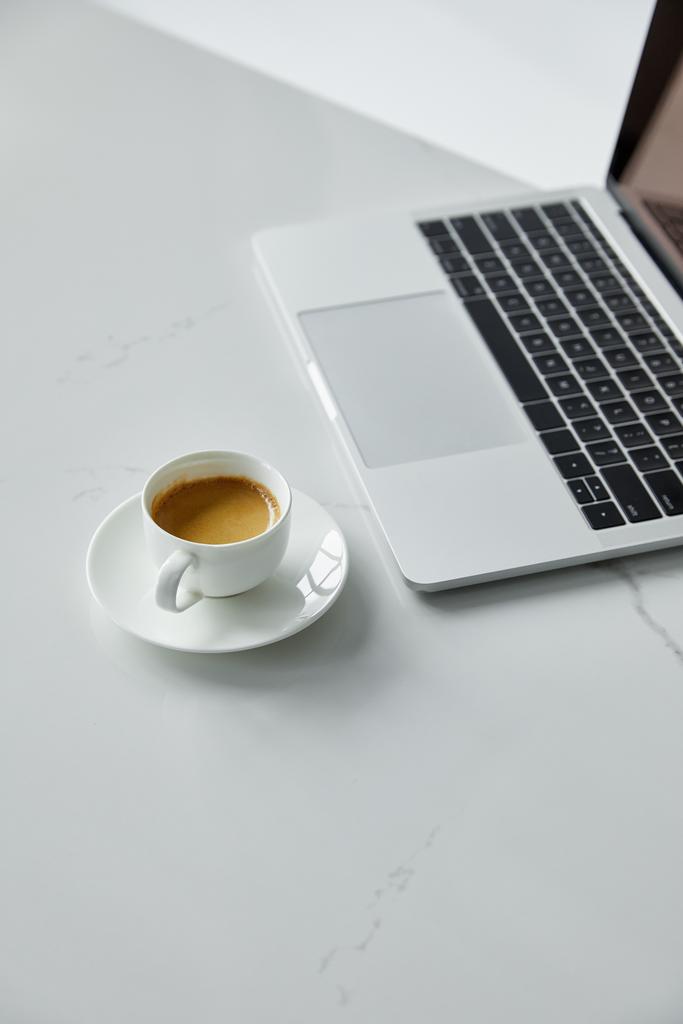 selectieve focus van laptop met zwart toetsenbord en koffie kopje geïsoleerd op grijs - Foto, afbeelding