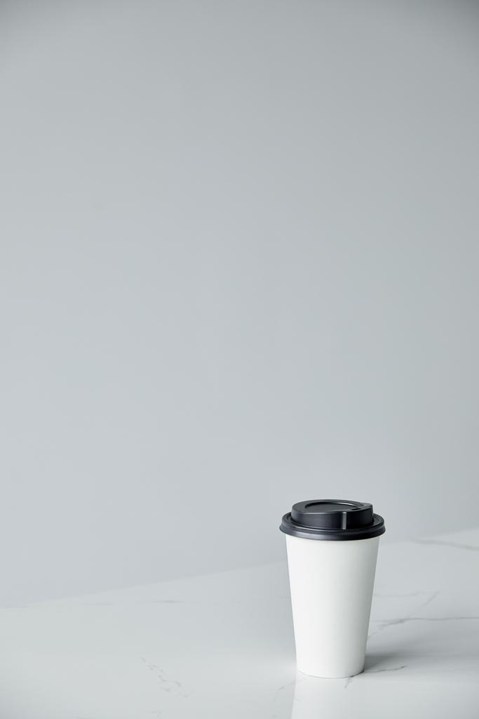 beyaz tek kullanımlık bardak siyah kap ile gri üzerinde kopya alanı ile izole - Fotoğraf, Görsel