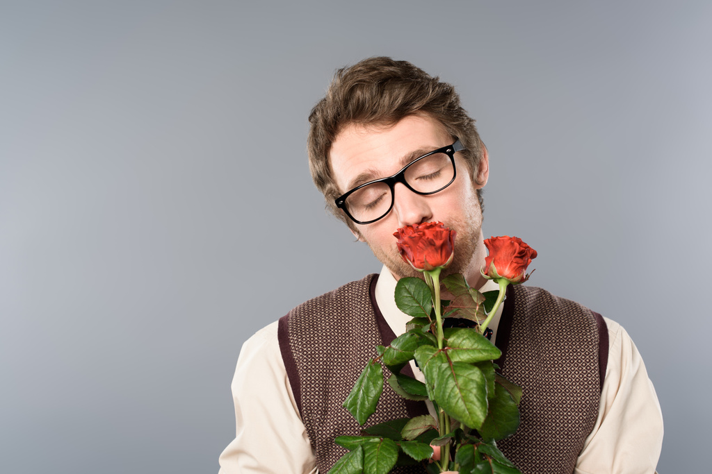 radosny człowiek w okularach z zamkniętymi oczami, pachnący bukiet róż - Zdjęcie, obraz