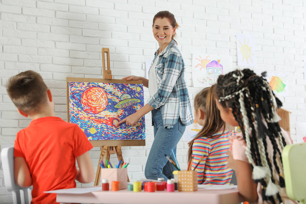 絵画レッスン室内で女教師と子どもたち - 写真・画像