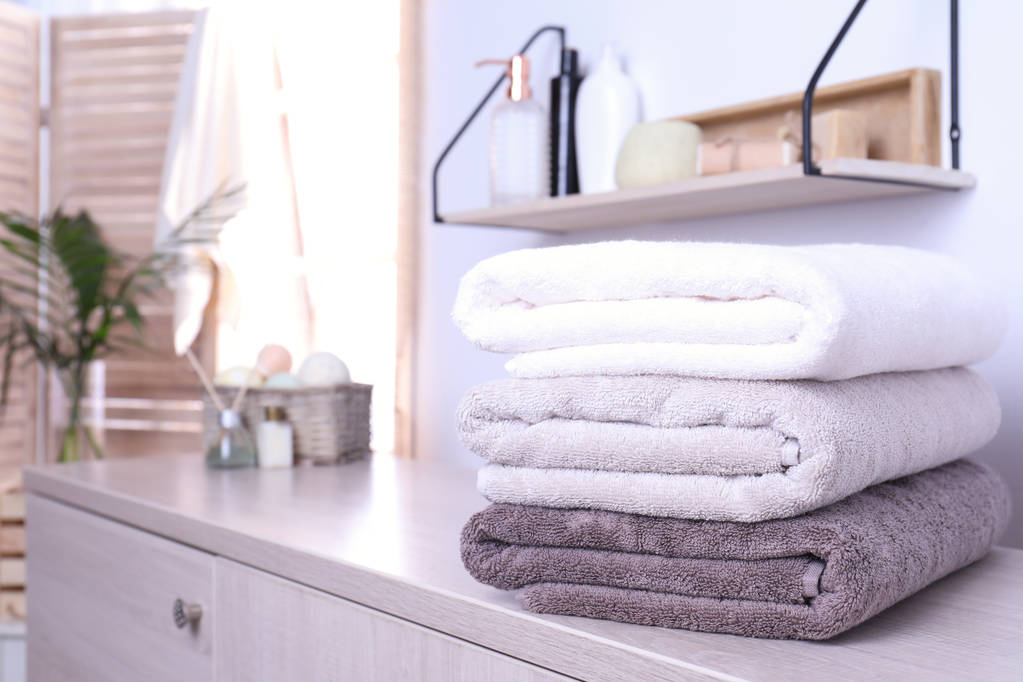 Pilha de toalhas frescas no armário no banheiro. Espaço para texto
 - Foto, Imagem