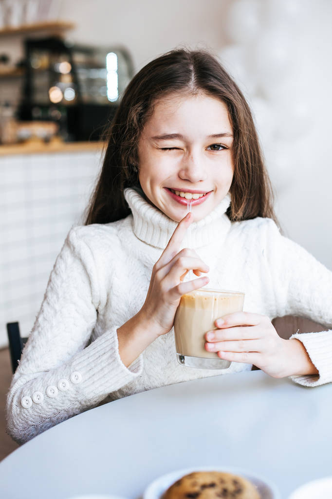 Smiling young girl drinking coffee - Photo, Image