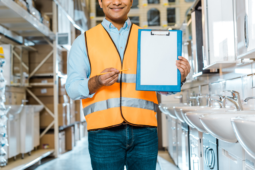 partial view of indian worker pointing at clipboard with blank paper  - Photo, Image
