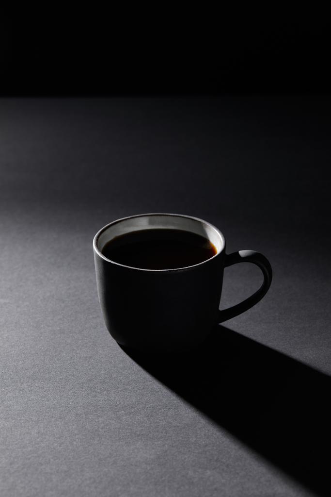 Cup of coffee on grey surface on black - Photo, Image