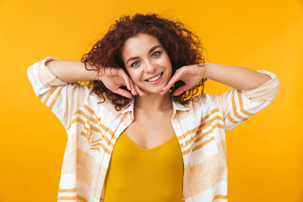 Obrazu, rudowłosej kobiety 20s z kręconymi włosami stałego i uśmiechając się - Zdjęcie, obraz