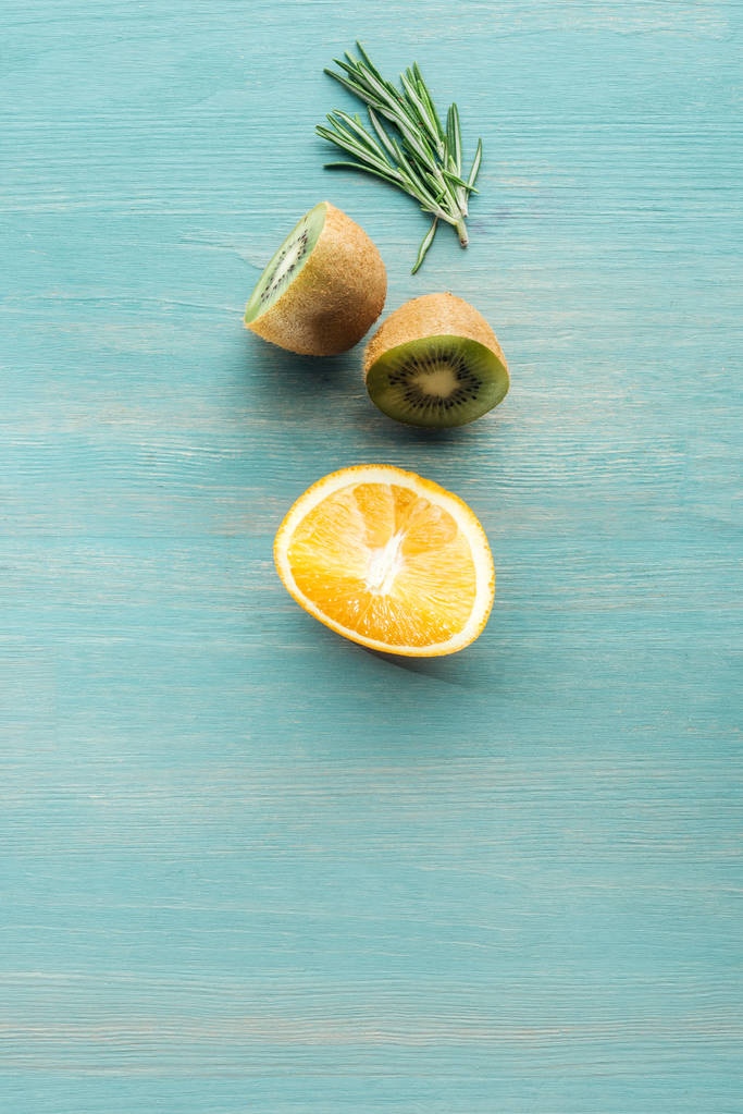 Top näkymä leikata hedelmiä ja rosmariinia sinisellä kuvioitu pinta
 - Valokuva, kuva