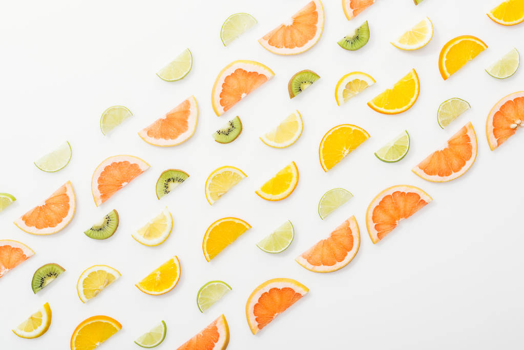 Acostado plano con jugosas frutas cortadas en la superficie blanca
 - Foto, imagen