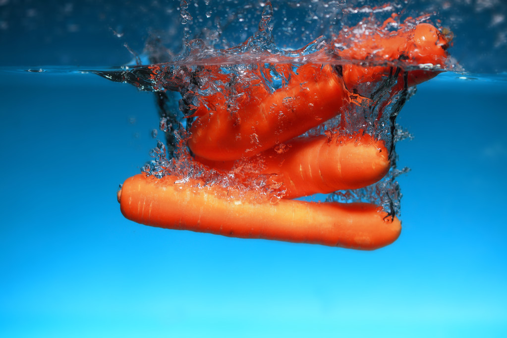 Zanahoria en el agua salpica sobre azul
 - Foto, Imagen