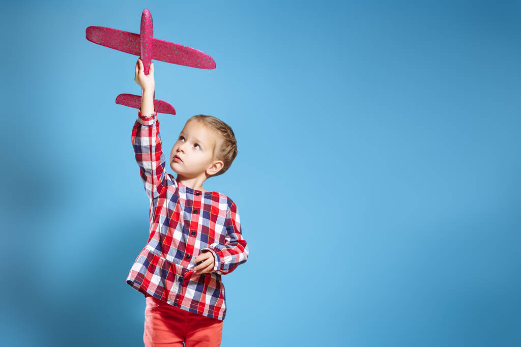 Ευτυχισμένο παιδί κορίτσι παίζει με αεροπλάνο παιχνίδι. το όνειρο να γίνει πιλότος. - Φωτογραφία, εικόνα