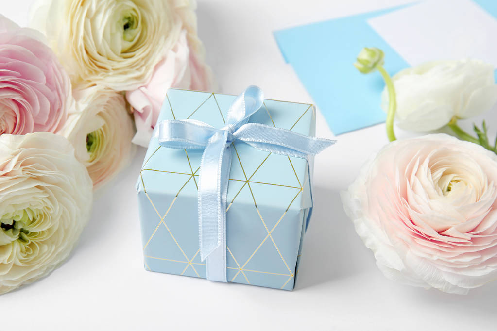 Hermosas flores ranúnculo, caja de regalo y sobre sobre fondo blanco
 - Foto, imagen