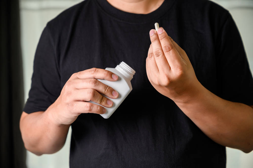 muž držel láhev medicíny šejk na bylinné doplnit pilulka  - Fotografie, Obrázek