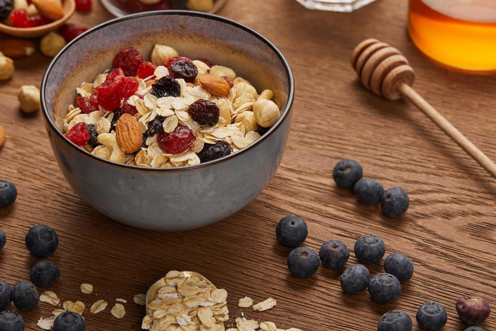 cereal in bowl with nuts and dried berries prepared for breakfast on wooden table - Photo, Image