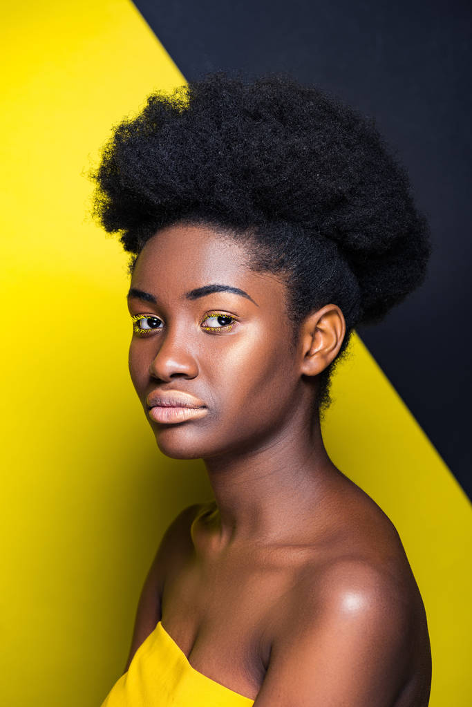 Vonzó afro-amerikai lány nézi kamera fekete és sárga - Fotó, kép