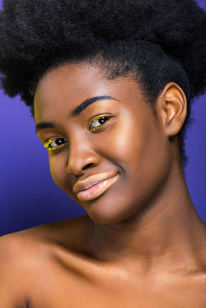 όμορφη αφρικανική αμερικανική νεαρή γυναίκα με κίτρινες βλεφαρίδες στο μωβ - Φωτογραφία, εικόνα