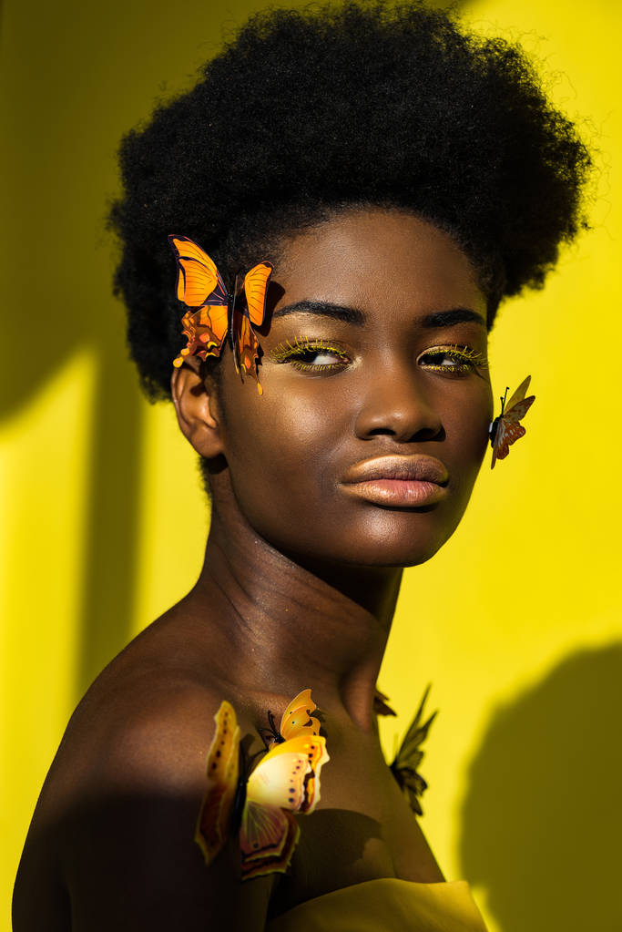 Atraktivní africká americká mladá žena s motýlama na žluté - Fotografie, Obrázek