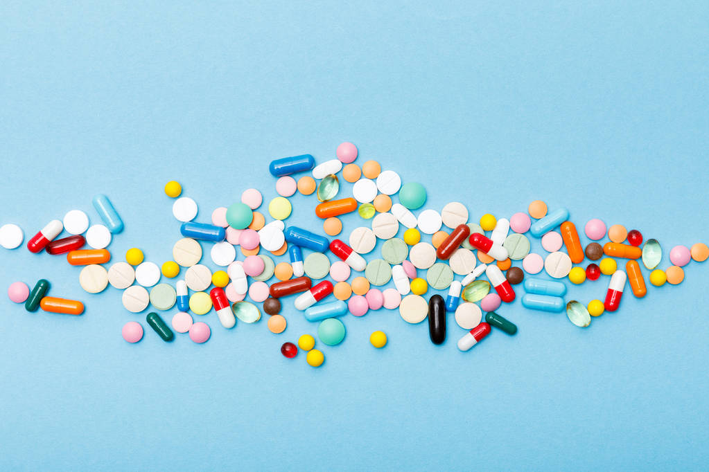 Vista dall'alto di pillole colorate sulla superficie blu
 - Foto, immagini