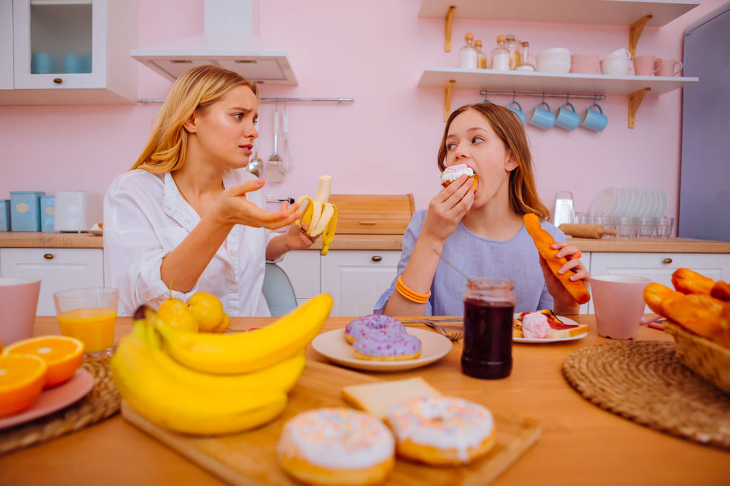 Huolehtiva isosisko kertoo sisarelleen, ettei syö paljon donitseja
 - Valokuva, kuva