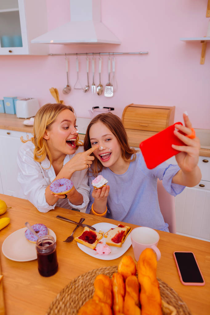 Duas irmãs encantadoras tendo incrível café da manhã familiar memorável
 - Foto, Imagem