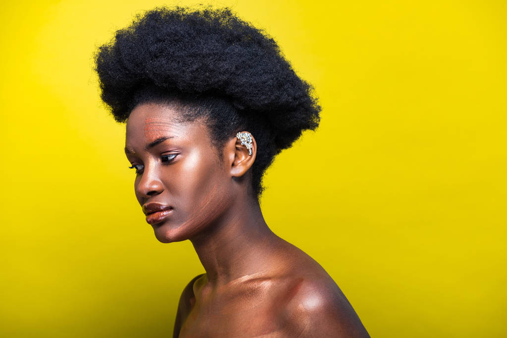 Mujer afroamericana atractiva pensativa con manguito en amarillo
 - Foto, imagen