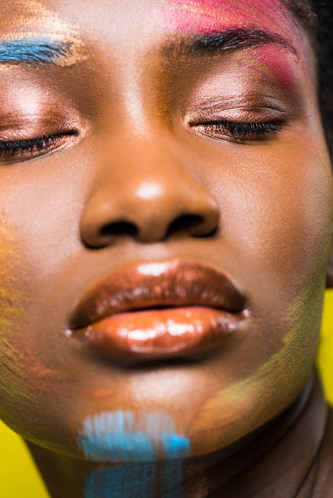 Enfoque selectivo de hermosa mujer afroamericana con maquillaje con los ojos cerrados
 - Foto, imagen