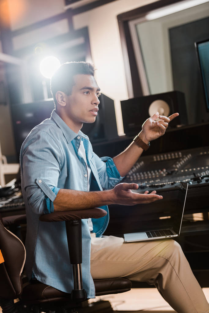 grave métissage producteur sonore gestuelle tout en étant assis à la console de mixage en studio d'enregistrement
 - Photo, image