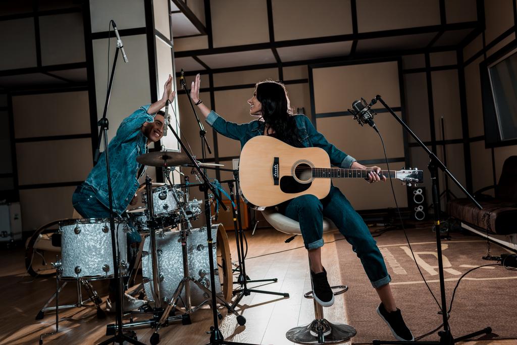 junge inspirierte multikulturelle Musiker geben High Five im Tonstudio - Foto, Bild