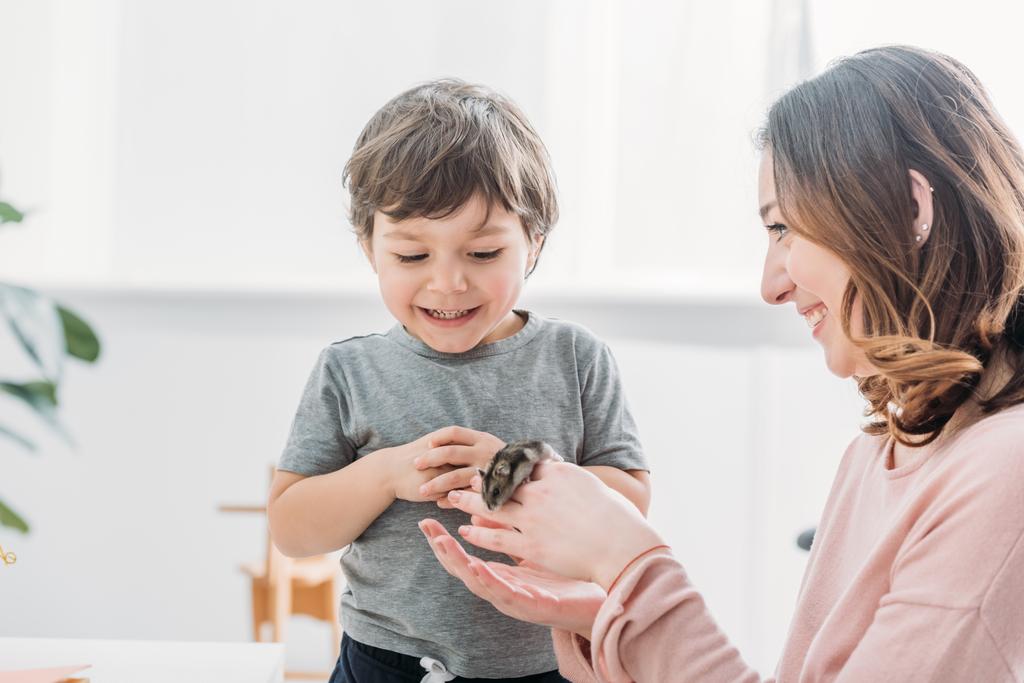 cheerful woman holding cute hamster near smiling adorable son - Photo, Image