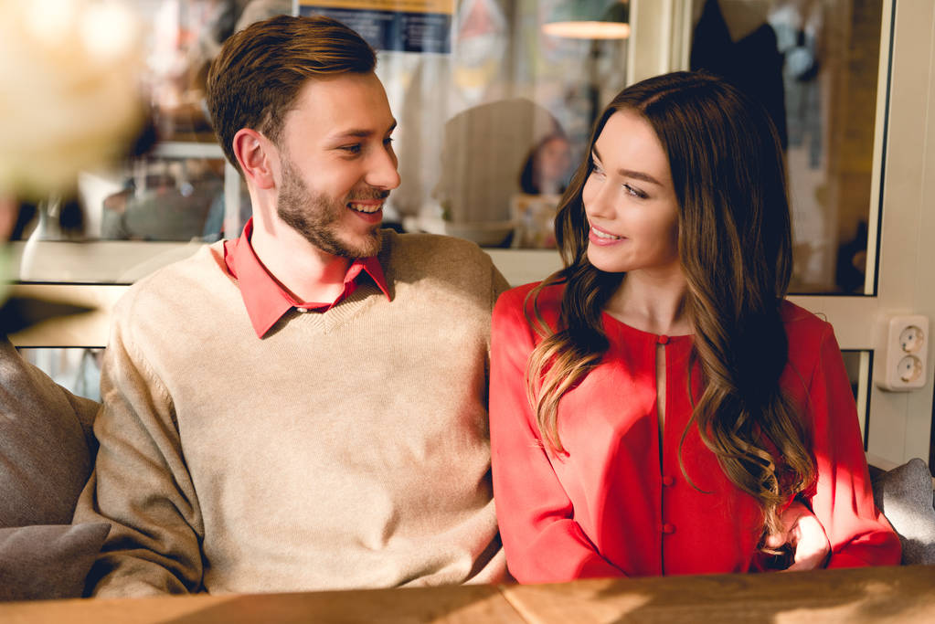 boldog ember és fiatal nő nézi egymást a kávézóban  - Fotó, kép
