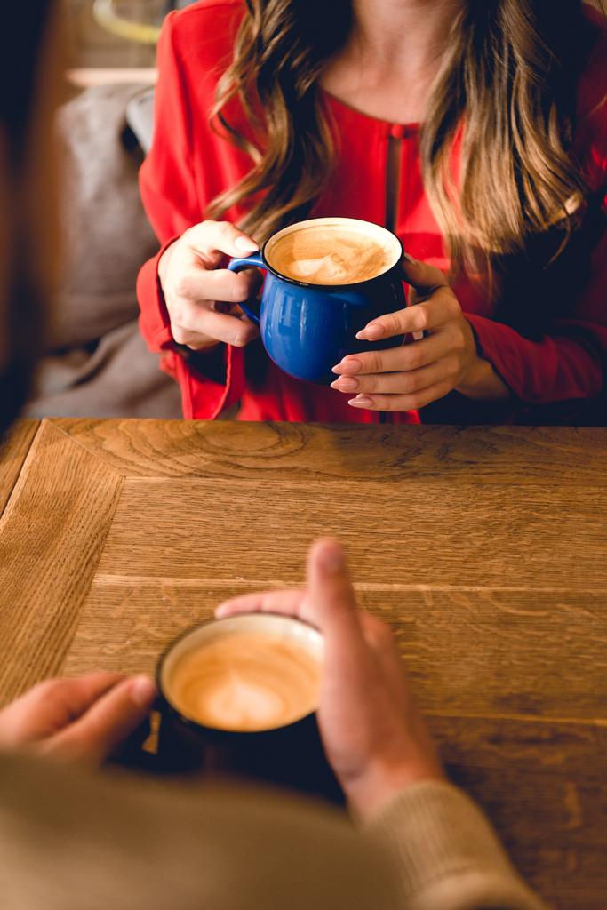 cropped view of man and woman holding cups with coffee in cafe  - Photo, Image
