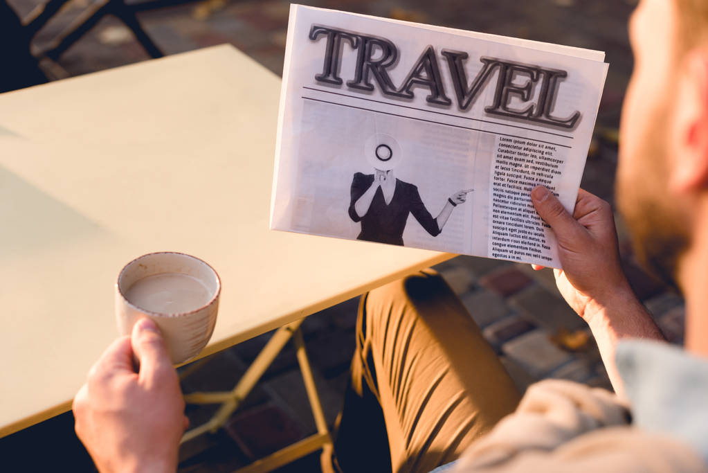 cropped view of man holding travel newspaper and cup of coffee  - Photo, Image