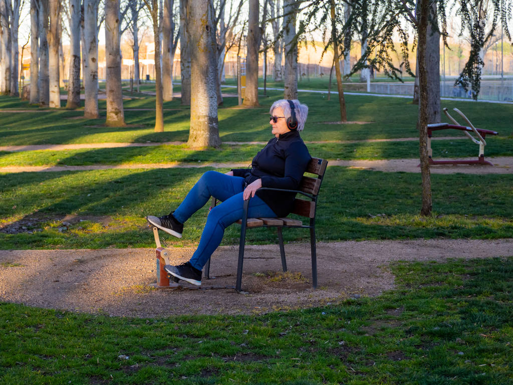 eine Seniorin mit weißem Haar turnt in einem bio-gesunden Park - Foto, Bild