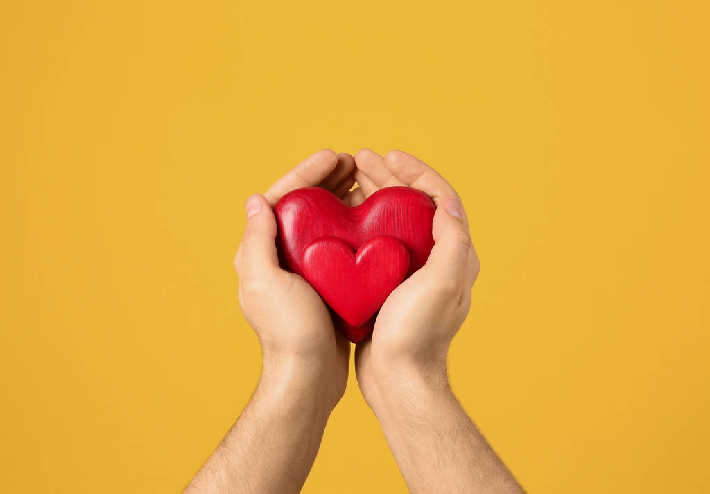 Ember dekoratív szívét tartja kezében a színes háttér, Vértes - Fotó, kép