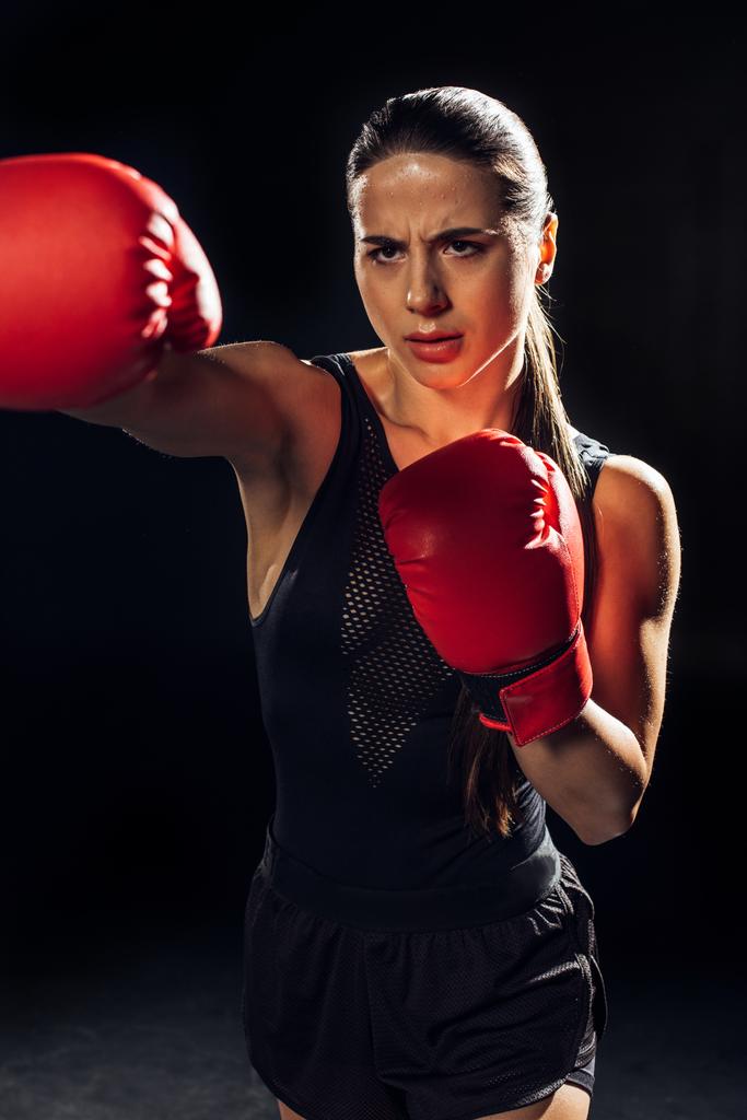 Kırmızı boks eldiven eğitimi odaklı kadın Boxer ve siyah üzerinde bakıyor - Fotoğraf, Görsel