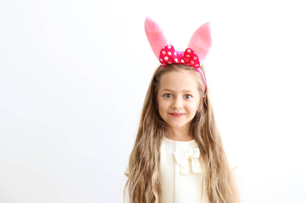 Smiling girl with bunny ears, white wall copy space background. - Photo, Image