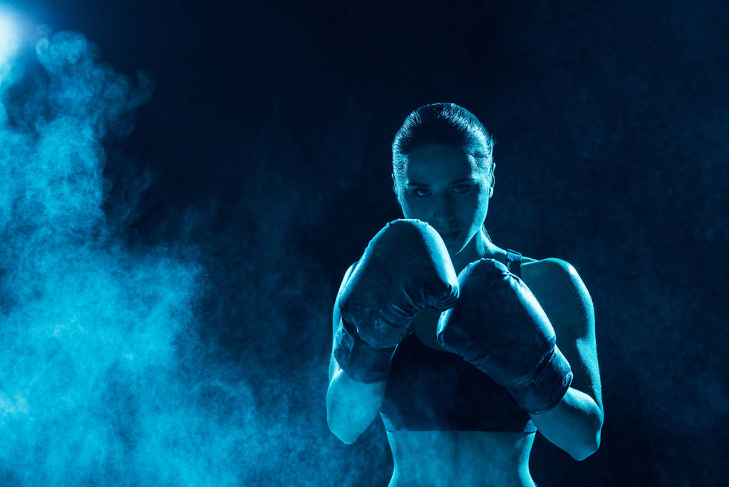 Frontansicht eines ernsthaften Boxers in Boxhandschuhen, der in die Kamera blickt - Foto, Bild