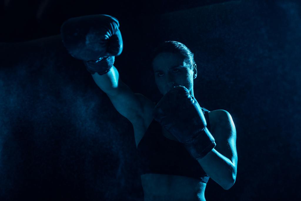Poważny bokser w Rękawice bokserskie szkolenia i patrząc z dala - Zdjęcie, obraz