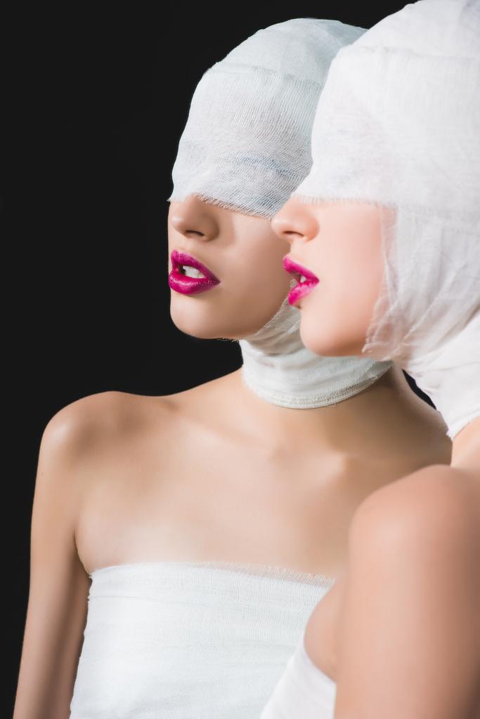 mirror reflection of girl with bandaged head and eyes isolated on black - Photo, Image