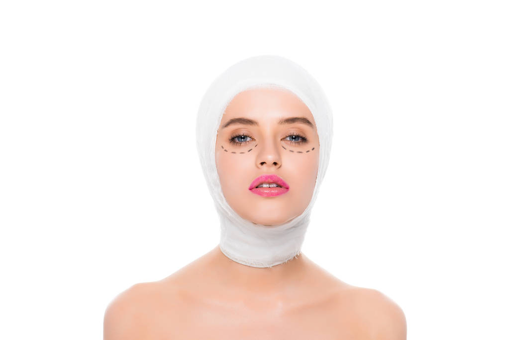 mujer joven desnuda con la cabeza vendada y marcas en la cara aislada en blanco
  - Foto, Imagen