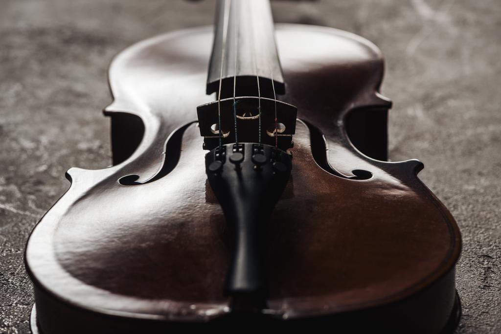 primo piano del classico violoncello in legno su sfondo grigio strutturato nel buio
 - Foto, immagini