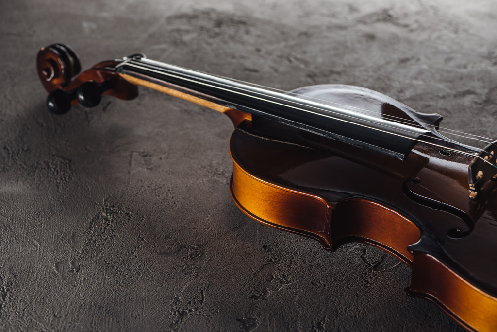 wooden classical violoncello in darkness on textured surface - Photo, Image