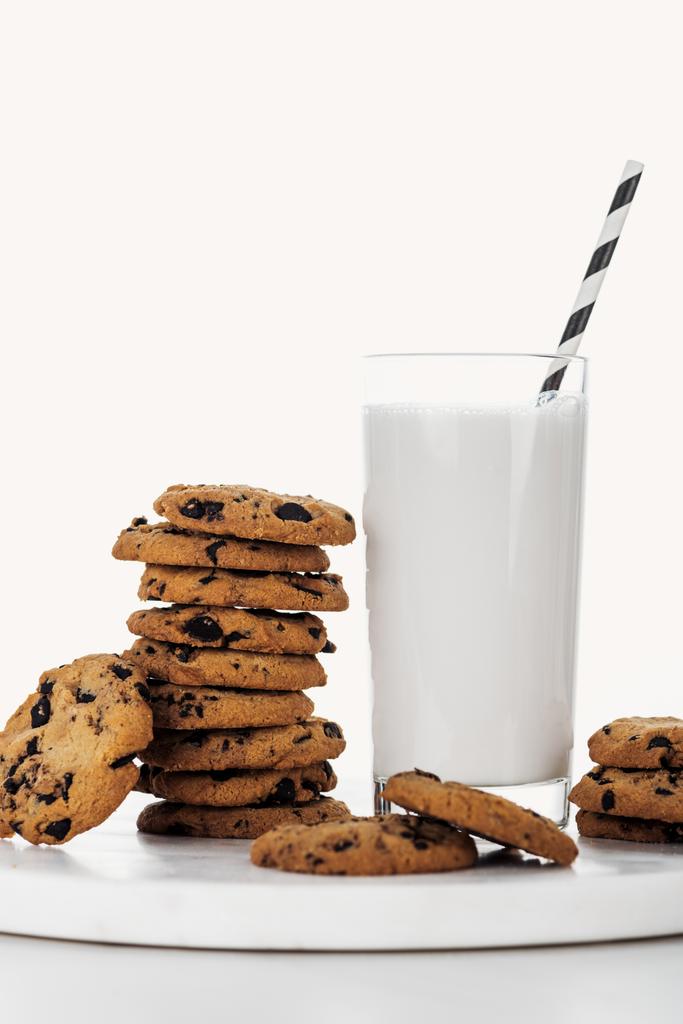 pile de délicieux biscuits au chocolat près du verre avec de la paille et du lait isolé sur blanc
 - Photo, image